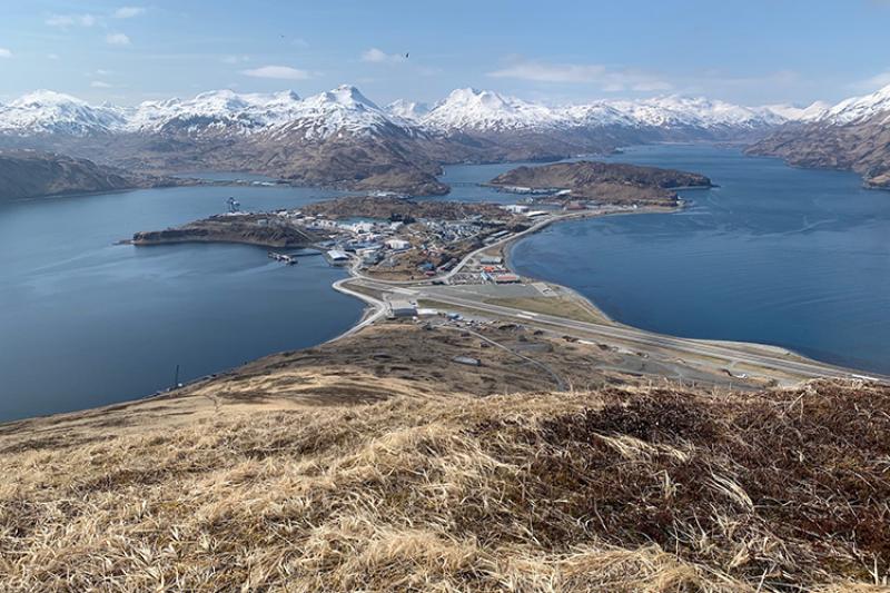On a hill looking out to two bodies of water and snowy mountains in the distance